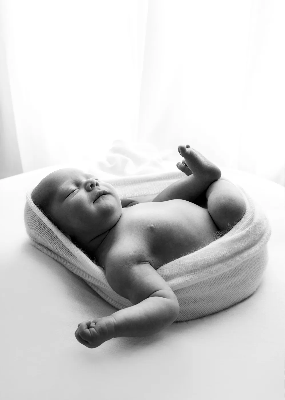 Newborn wrapped in soft fabric